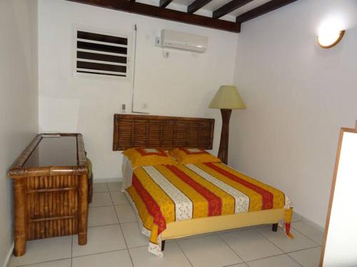 1 dormitorio con cama, lámpara y mesa en Belle Villa au cœur de la Gwada, en Le Gosier