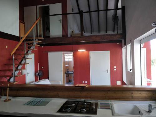 una cocina con paredes rojas y una escalera en una habitación en Belle Villa au cœur de la Gwada en Le Gosier