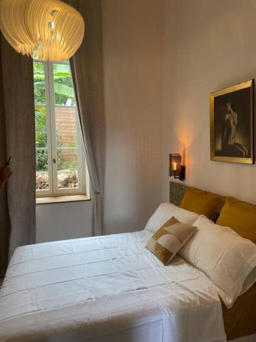 Schlafzimmer mit einem weißen Bett und einem Fenster in der Unterkunft Appartement chic et de caractère ! in Saint-Cyr-au-Mont-dʼOr