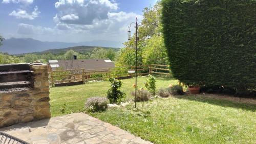 een uitzicht op een tuin met een grote bush bij Maison en Cerdagne avec belle vue in Enveitg