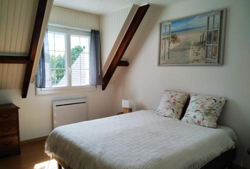 a bedroom with a bed and two windows at Le Sanctuaire in Missillac