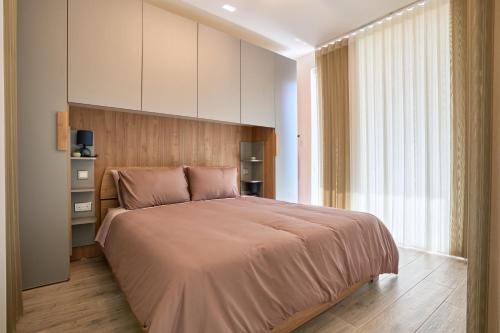Un dormitorio con una cama grande y una ventana grande. en Gzira Highly Finished Apartment, en Il-Gżira