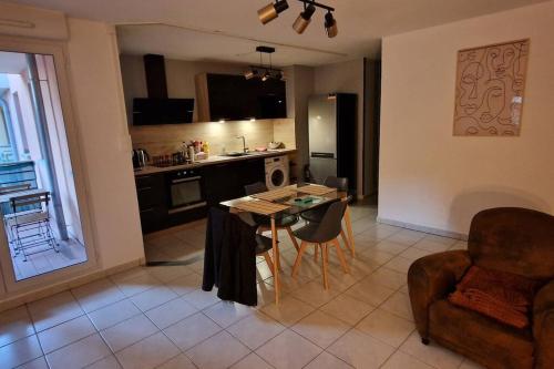 cocina y sala de estar con mesa y sillas en Les Capucins - Centre ville - Parking inclus en Belfort