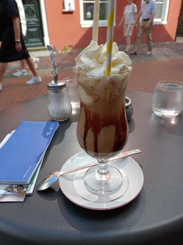 a drink in a glass on a table at Ediths Haus in Rhauderfehn