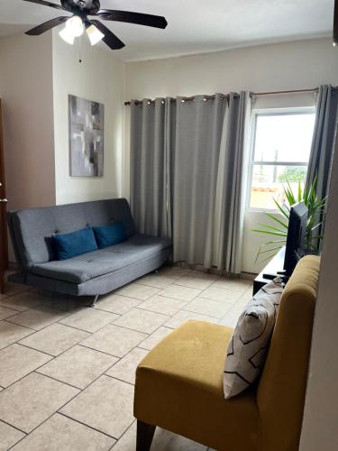 a living room with a couch and a window at Departamentos Hergoz in Ciudad Fernández