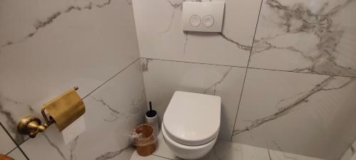 a white toilet in a bathroom with marble walls at XuBa ApartmentRooms Messe Wien Prater in Vienna