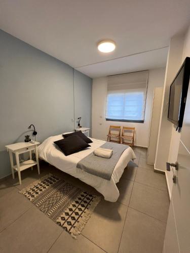 a bedroom with a large bed and a television at Family Apartment By IsrApart in Ramat Gan