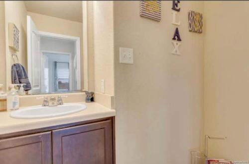 een badkamer met een wastafel en een spiegel bij Hme Away from Hme in San Antonio