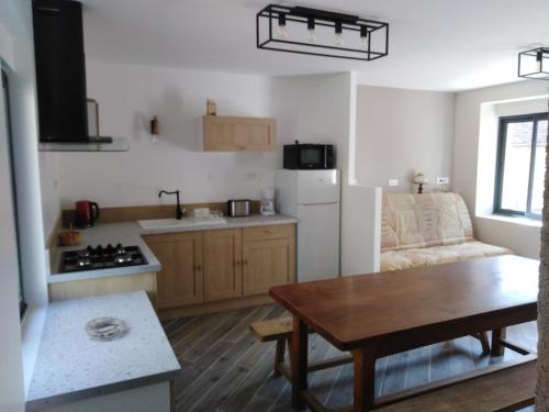 eine Küche und ein Wohnzimmer mit einem Tisch und einem Sofa in der Unterkunft Gîte mon p'ti bout in Les Roches-lʼÉvêque