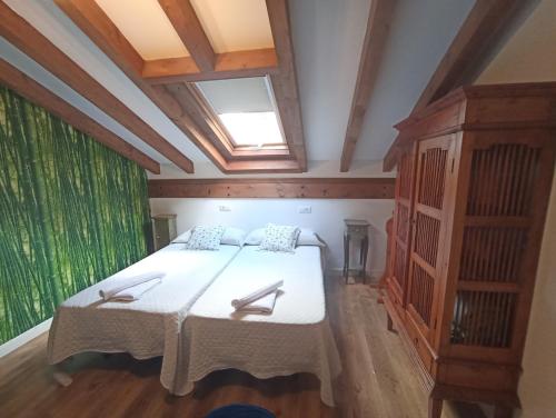 a bedroom with a large bed and a window at VIVIENDAS RURALES LAS CALDERAS in Santillana del Mar