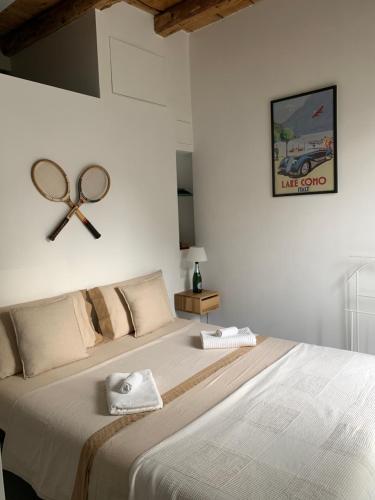 a bedroom with a large bed with a racket on the wall at Villa Paola - Holiday Apartment - Menaggio, Lago di Como in Menaggio