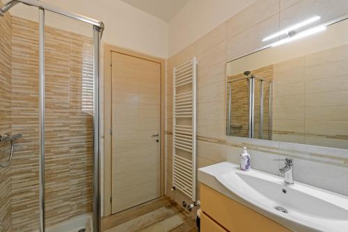 bagno con lavandino, doccia e specchio di CASA REFENERO a Torrita di Siena
