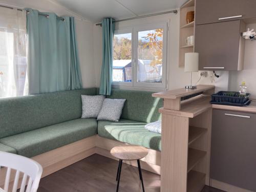 un salon avec un canapé vert et une table dans l'établissement Camping Mas Piques, à Bourg-Madame