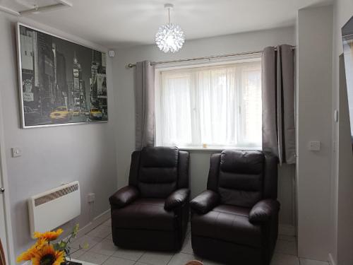 a living room with two chairs and a window at Lister Park Bradford Stylish 1bed Coach House - Quiet & Tranquil Cottage & Parking in Bradford