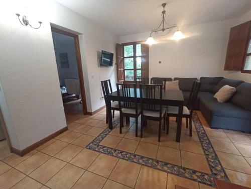 a dining room and living room with a table and chairs at VIVIENDAS RURALES LAS CALDERAS in Santillana del Mar