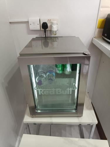 a small refrigerator with bottles of water in it at Lister Park Bradford Stylish 1bed Coach House - Quiet & Tranquil Cottage & Parking in Bradford