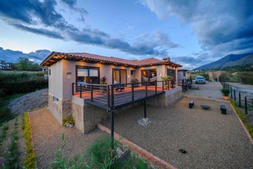 a small house with a large deck on a driveway at Casa de las Flores- Buganvilias in Villa de Leyva