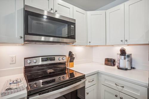 a kitchen with white cabinets and a microwave at Madeira Bay Resort I 1505 in St Pete Beach
