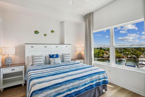 a white bedroom with a bed and a large window at Madeira Bay Resort I 1505 in St Pete Beach