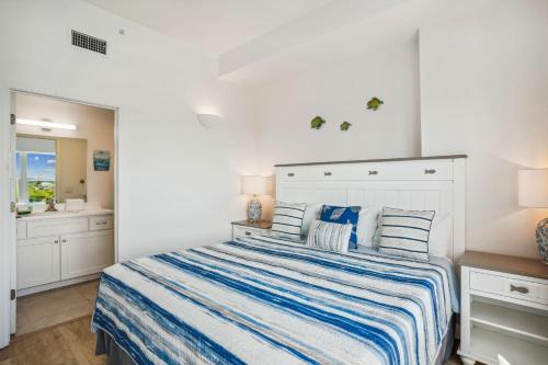 a bedroom with a bed with a blue and white striped comforter at Madeira Bay Resort I 1505 in St Pete Beach