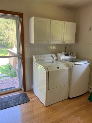 eine Küche mit einer Waschmaschine, einem Trockner und einem Fenster in der Unterkunft Private House in Somerset/New Brunswick Central Jersey 