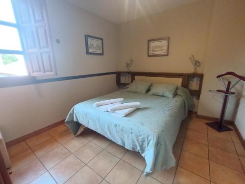 a bedroom with a bed with two towels on it at VIVIENDAS RURALES LAS CALDERAS in Santillana del Mar
