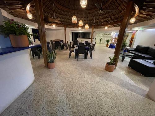 una sala de estar con mesas y sillas y un comedor. en Hotel Palma Azul Beach, en Coveñas
