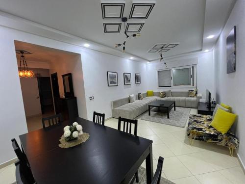 comedor y sala de estar con mesa y sofá en Residence meaxpa adres Av Youssef ibn tachfine 4 Tanger, en Tánger