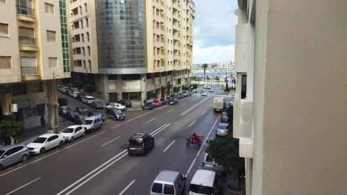 Una vista de una calle de la ciudad con coches y edificios. en Residence meaxpa adres Av Youssef ibn tachfine 4 Tanger, en Tánger