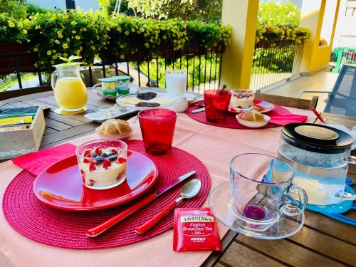 a table with a red plate of food and drinks at Bed and Breakfast L'Albero Maestro in Borgofranco dʼIvrea