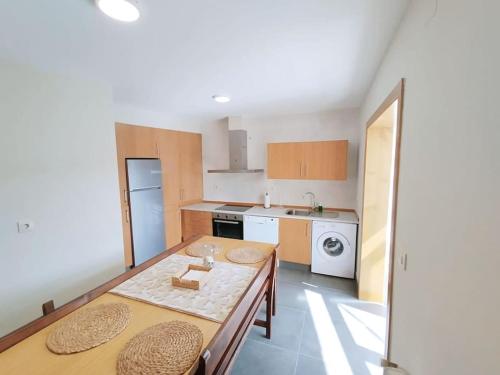 a kitchen with a dining table and a kitchen with a refrigerator at Vila María in Castrelo de Miño