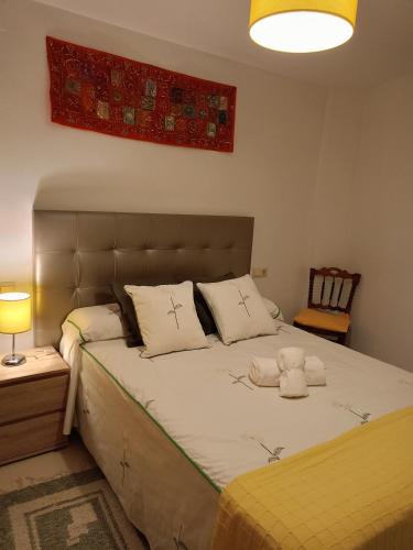 a bedroom with a large bed with two pillows at Reyes in Monachil