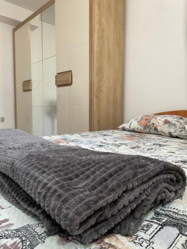a bedroom with a bed with a blanket on it at JOVAN APARTMAN in Rospi Ćuprija