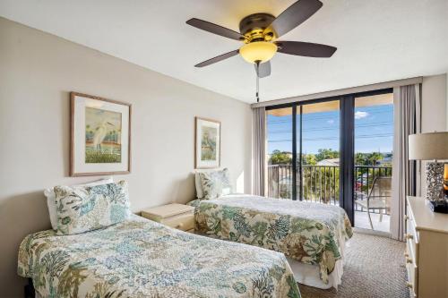 a bedroom with two beds and a ceiling fan at Trillium 2A - Premier in St. Pete Beach