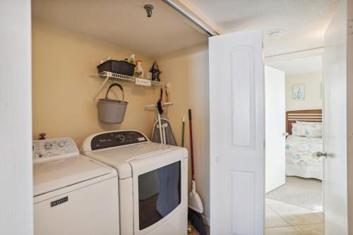 a laundry room with a stove and a washer at Trillium 2A - Premier in St. Pete Beach