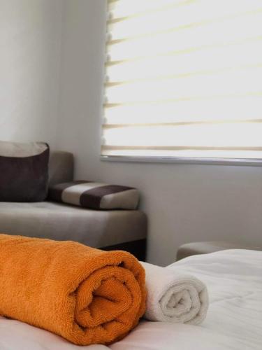 a pile of towels on a bed in a room at Apartmani Šarović in Tjentište