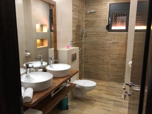 a bathroom with two sinks and a toilet and a shower at Apart Lux Beciragic in Dobra Voda
