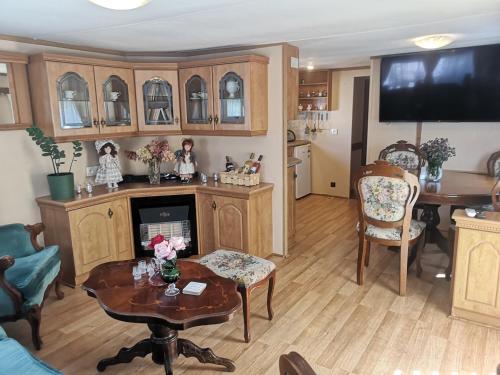 a living room with wooden cabinets and a table and a tv at Agroturystyka u Kozdryka in Leśna