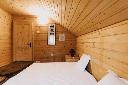 a room with a bed in a wooden cabin at Forest Garden & House in Izvoare