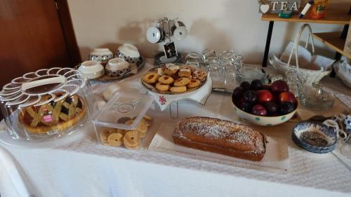 une table avec différents types de nourriture et de desserts dans l'établissement Domo Is Domus, à SantʼAnna Arresi