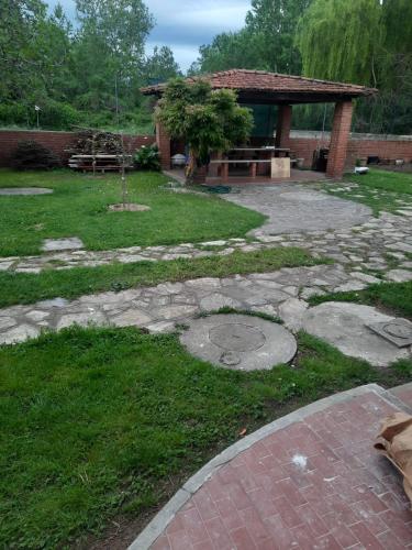 un jardín con un patio de piedra y un pabellón en Bilocale in zona tranquilla Tirrenia, en Tirrenia