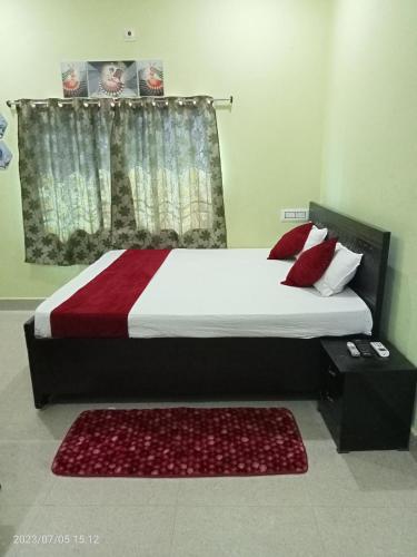 a bedroom with a large bed with red pillows at Hotel Narayani in Rājgīr