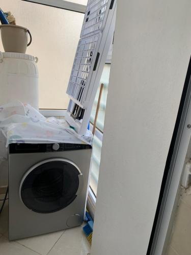 a washing machine sitting in a room with a shelf at Appartement cosy et pratique in Oujda