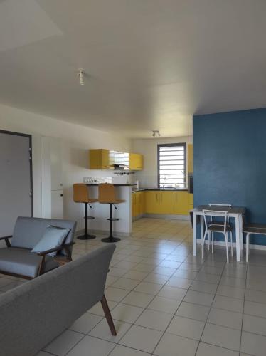 a living room with a couch and a table at La Coraline Standing in Kourou