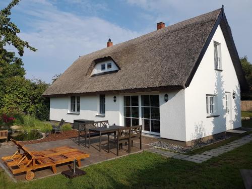 Ce cottage blanc dispose d'une table de pique-nique et d'une terrasse. dans l'établissement Wohlfuehl-Orte24 am Hafen in Schaprode, Rügen, à Schaprode