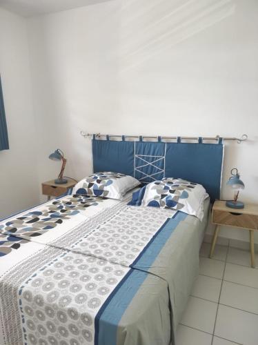 a blue and white bed with two pillows on it at La Coraline Standing in Kourou