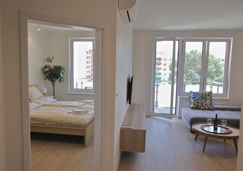 ブラチスラヴァにあるLuxury Grand Apartments by Bratislavatripのベッド、ソファ、テーブルが備わる客室です。
