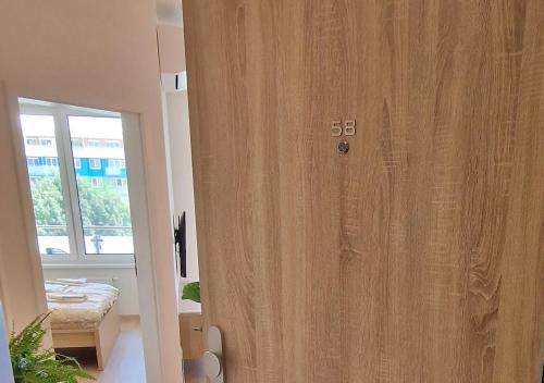 Una puerta de madera en una habitación con ventana en Luxury Grand Apartments by Bratislavatrip en Bratislava