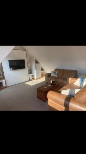 a living room with a couch and a tv at Storm Cottage B&B in Hugh Town