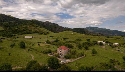 an aerial view of a green field with a house at Yan's House in Alaverdi